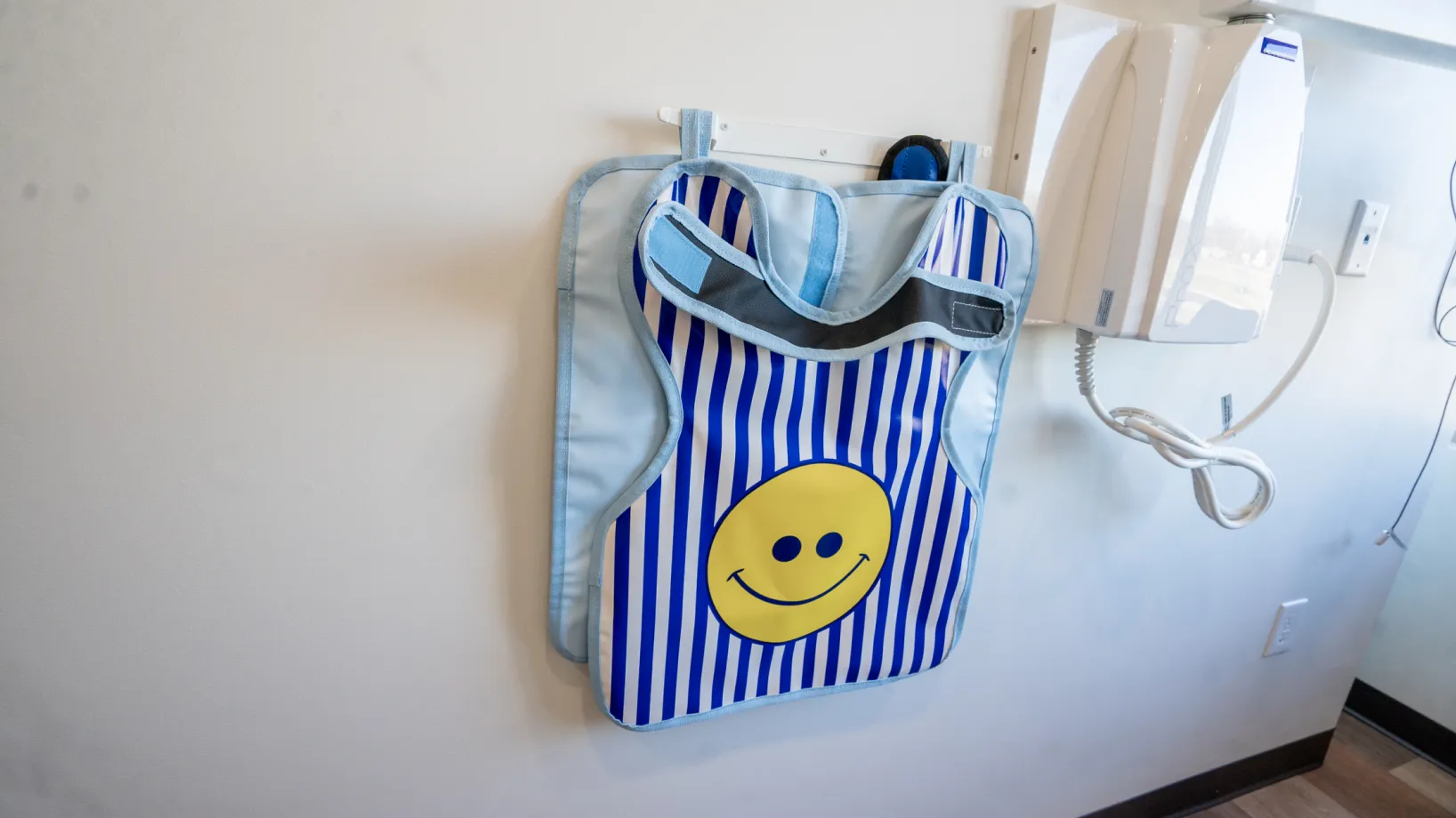 A blue and white striped bag hanging on a wall.