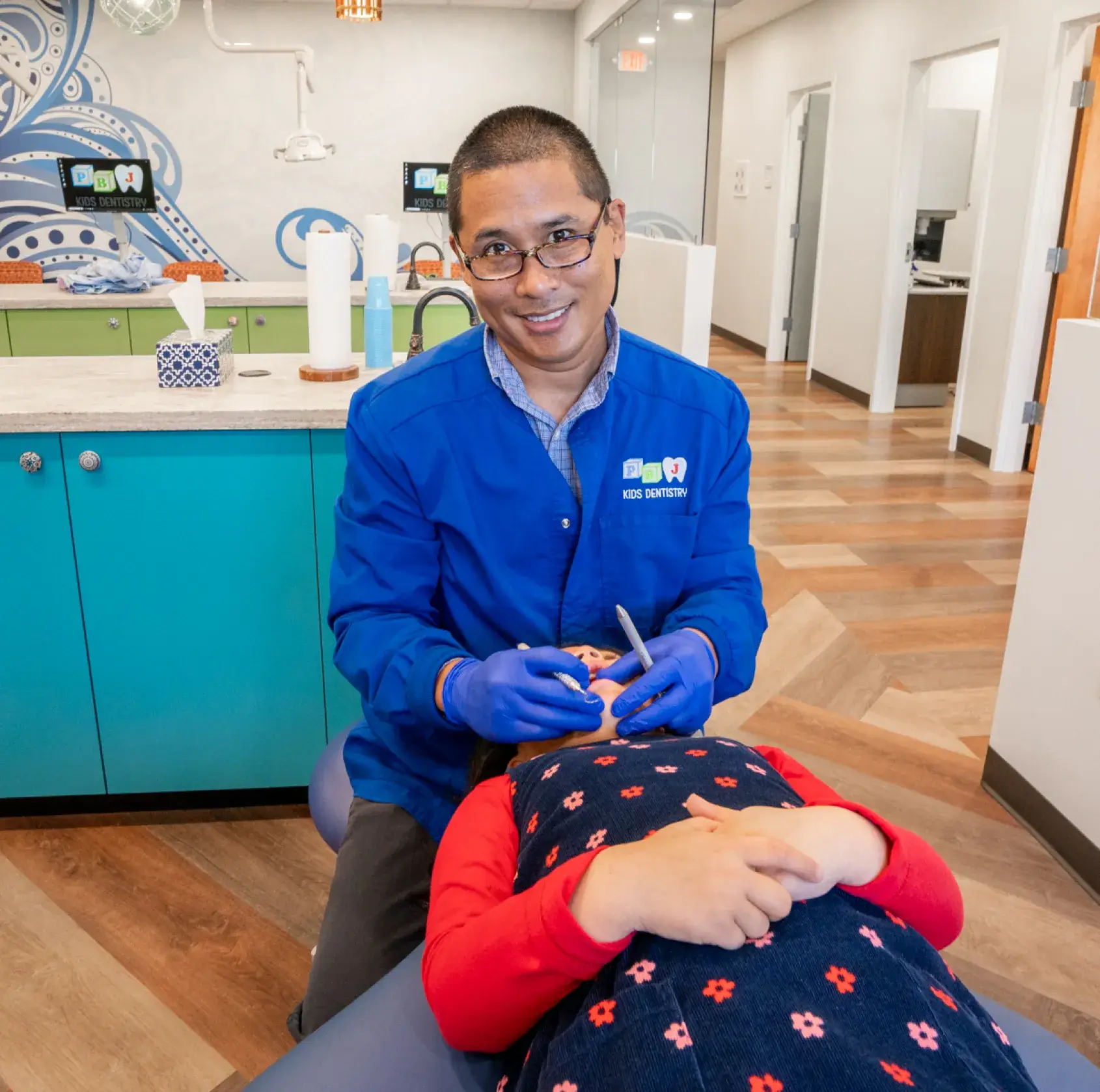 A man in a blue shirt getting his teeth checked.