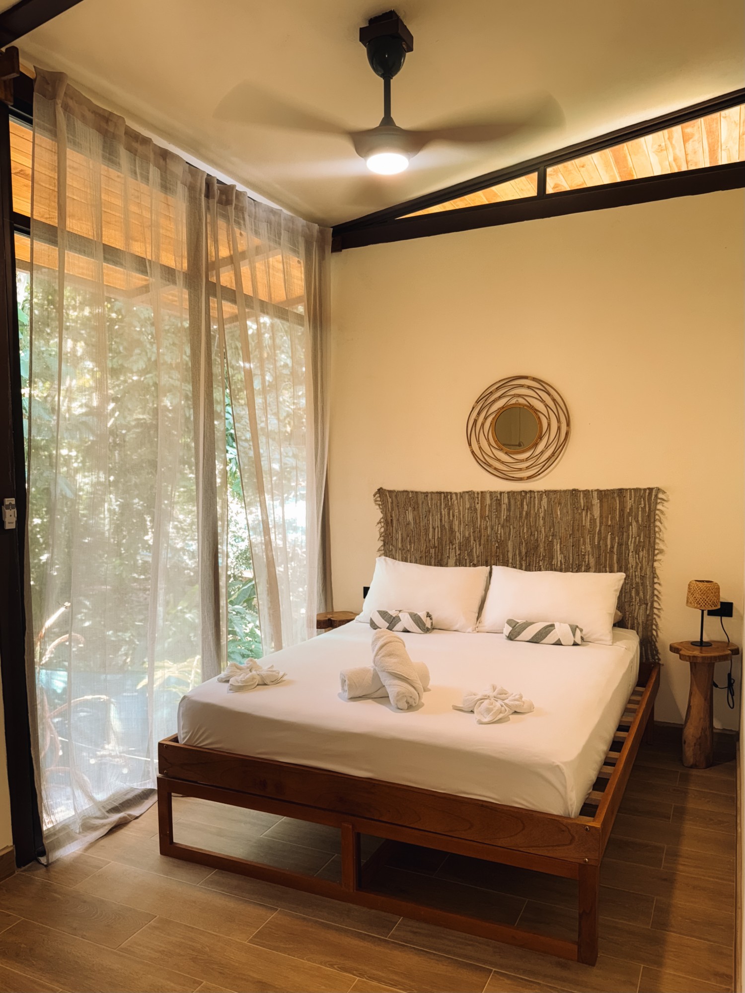 Bedroom opening onto the jungle through a floor-to-ceiling window