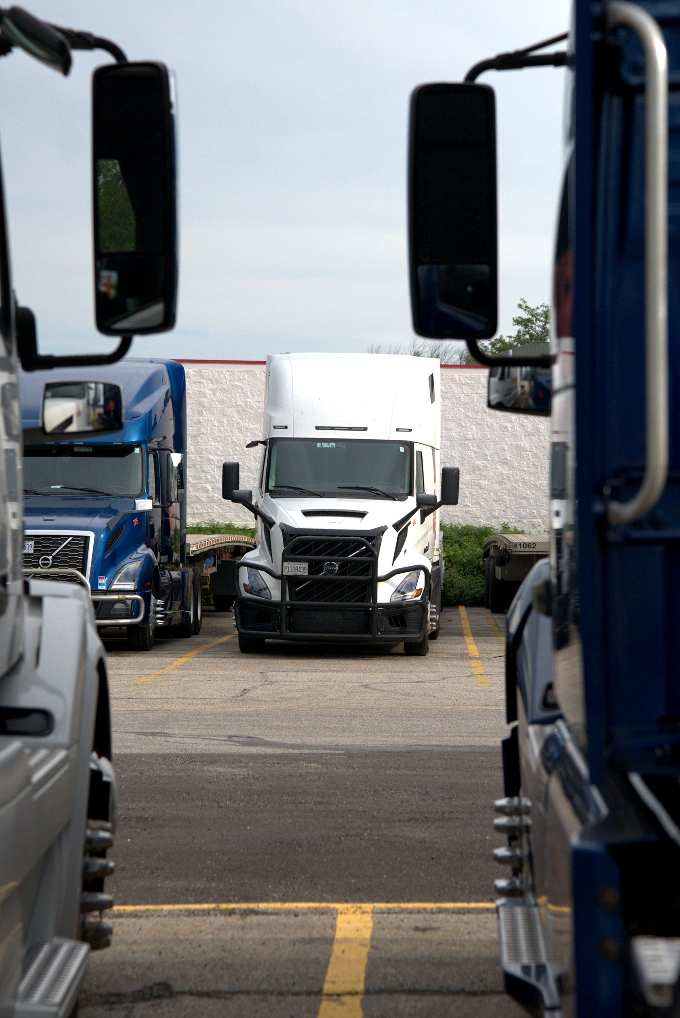 Stellar Cargo tractor viewed between two parked trucks in the yard