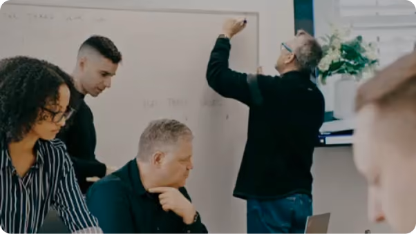 Design team collaborating at a whiteboard during a discovery workshop