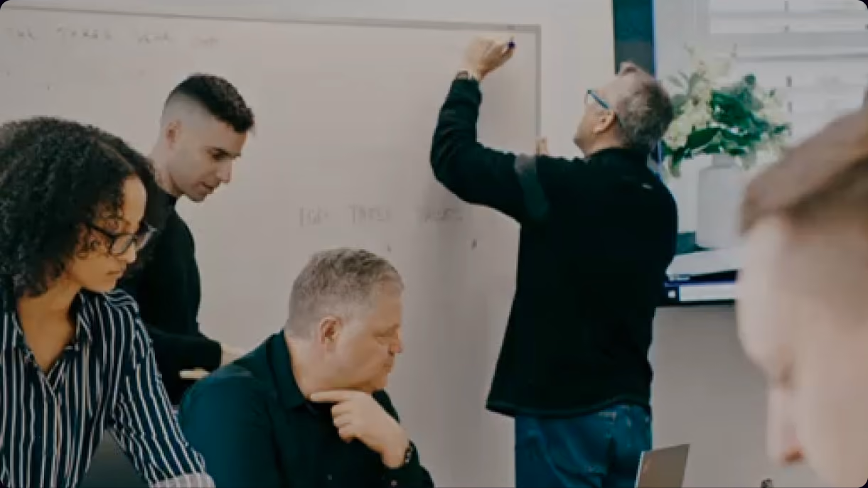 Design team collaborating at a whiteboard during a discovery workshop
