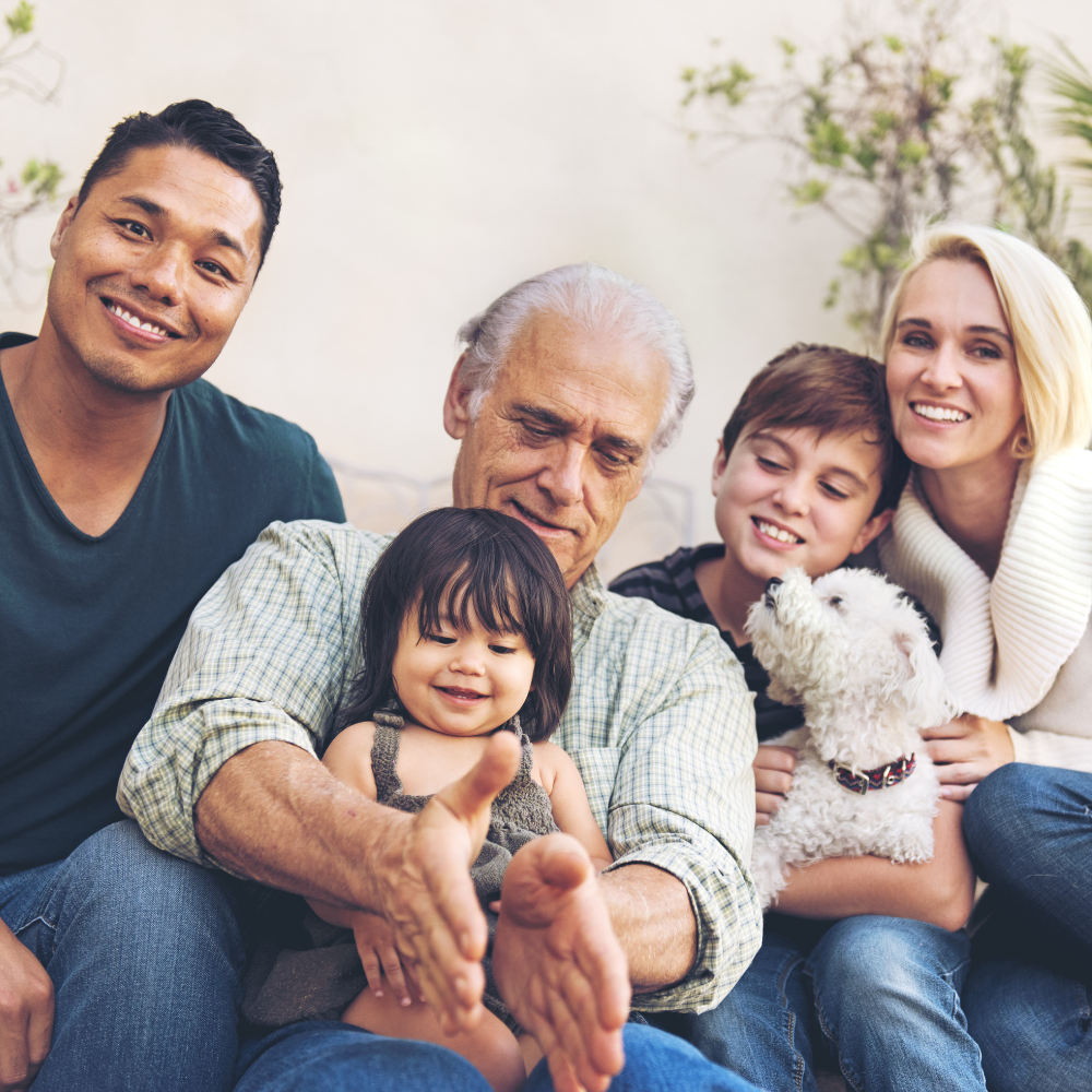 A multigenerational family sitting together outside