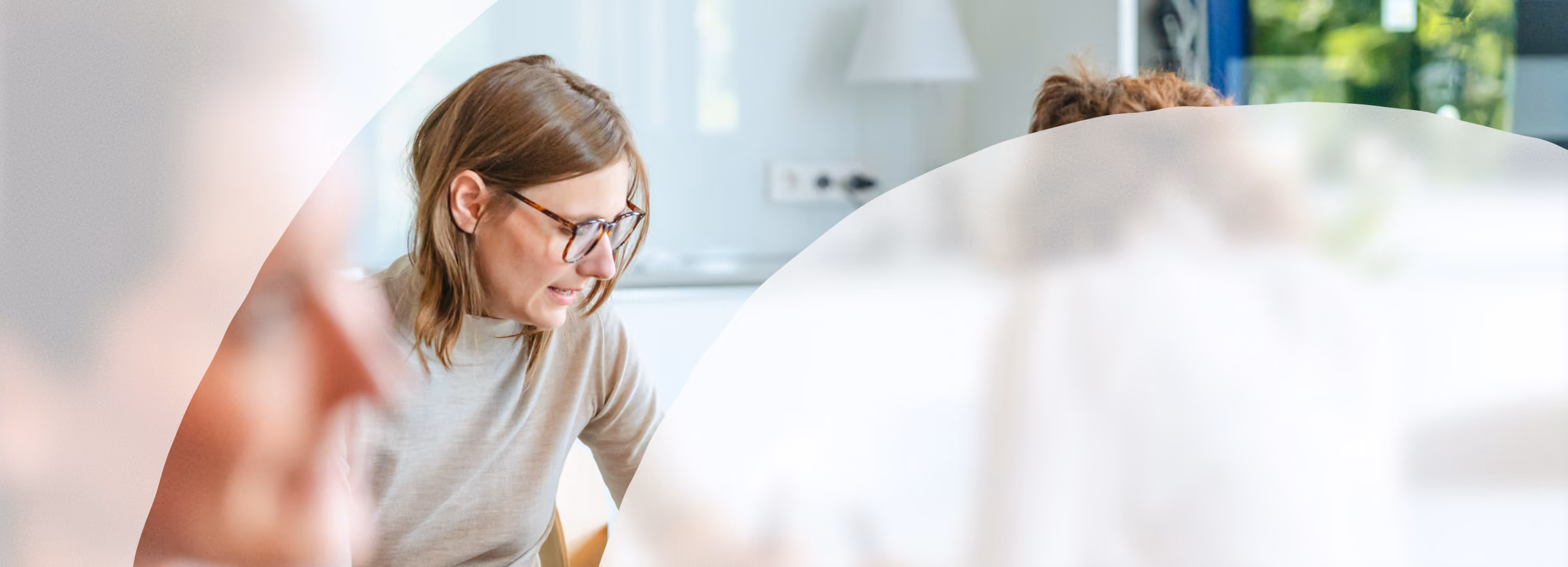 Kleine Gruppe von Frauen arbeitet gemeinsam an einem Tisch in einem hellen Workshopraum.