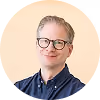Porträt eines lächelnden Coaches mit Brille.