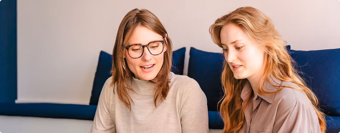 Zwei Frauen betrachten gemeinsam einen Laptop.