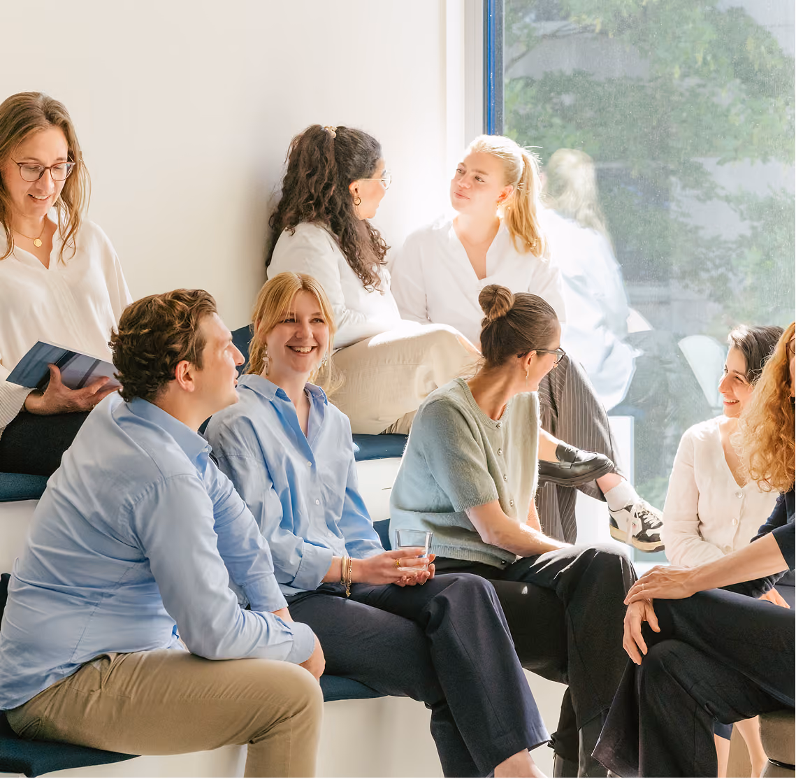 Gruppe sitzt bei einem Gespräch oder Workshop zusammen.