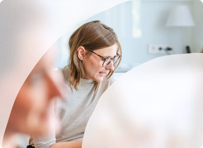 Frau mit Brille arbeitet konzentriert an ihrem Laptop.