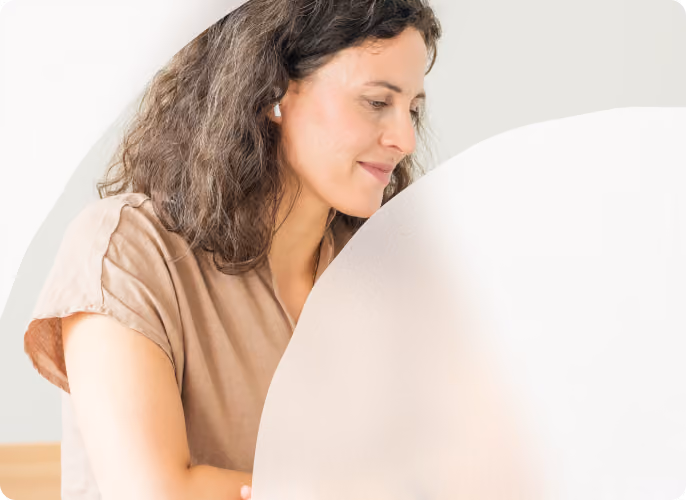 Frau mit lockigem Haar arbeitet am Laptop.