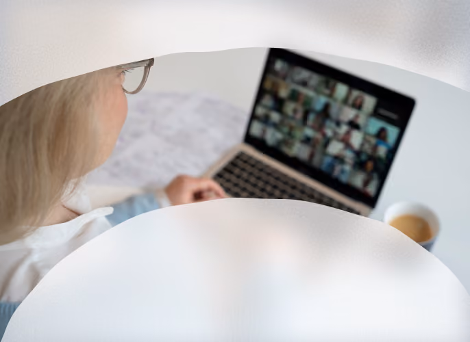 Frau betrachtet ein Videogespräch auf ihrem Laptop.