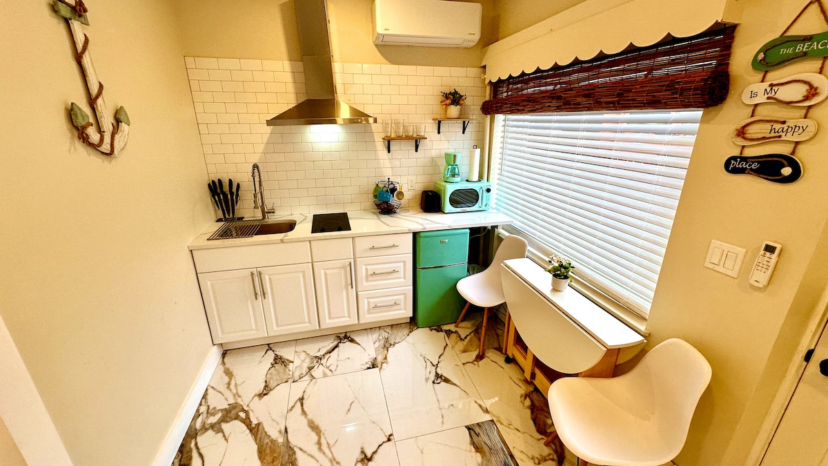 Experience the convenience of a full kitchen, complete with an electric cooktop and a foldable dining table