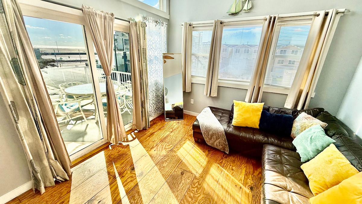 Second-floor living room with Italian leather sofa and access to a top deck featuring ocean views—perfect for morning co
