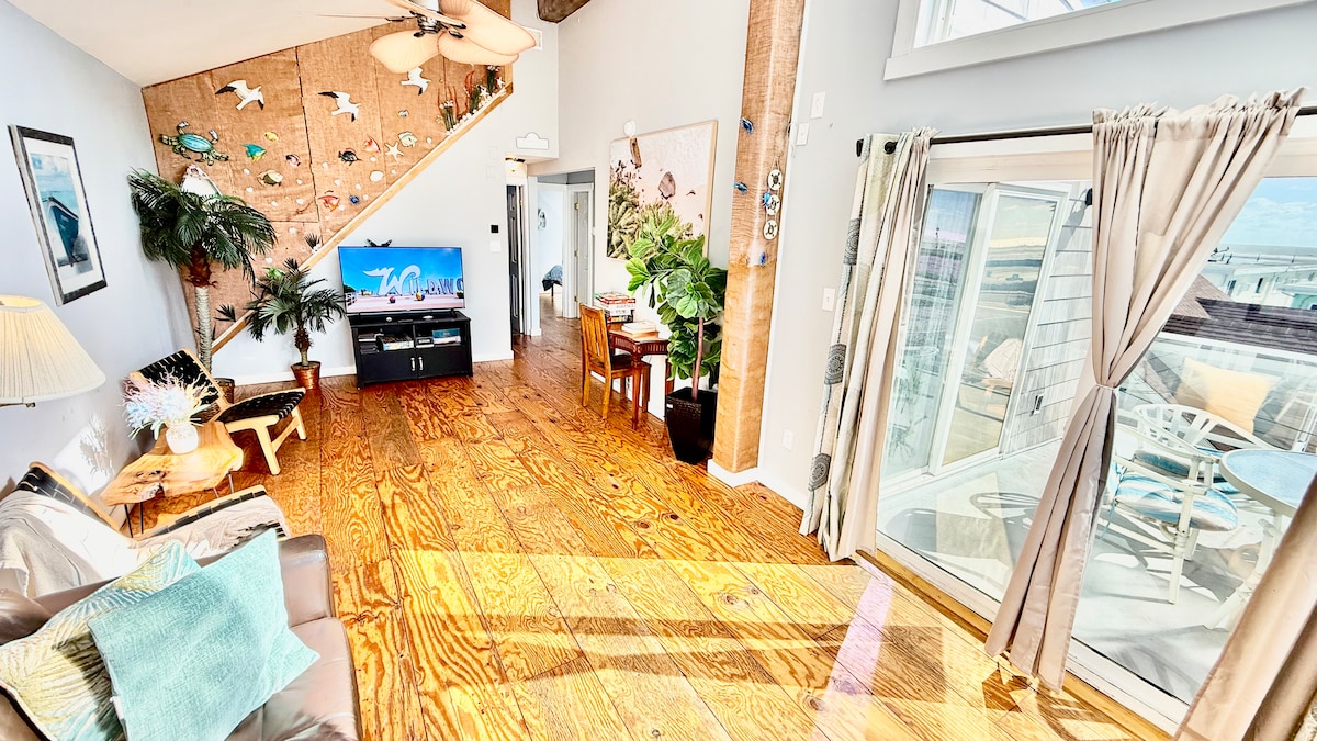 Second-floor living room with Italian leather sofa and access to a top deck featuring ocean views—perfect for morning co