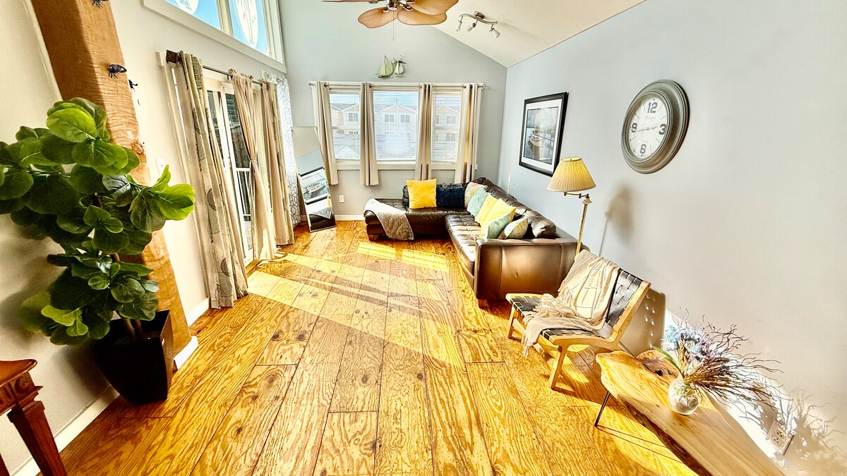 Second-floor living room with Italian leather sofa and access to a top deck featuring ocean views—perfect for morning co