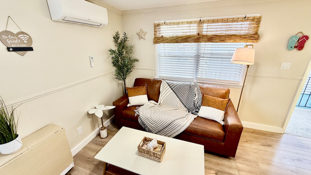 Bright and functional living area with a full kitchen, folding dining table, and a pull-out queen sofa. Every detail fol