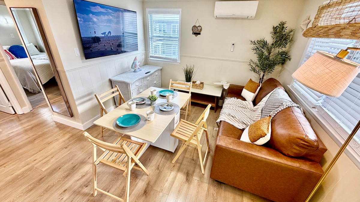 Bright and functional living area with a full kitchen, folding dining table, and a pull-out queen sofa. Every detail fol