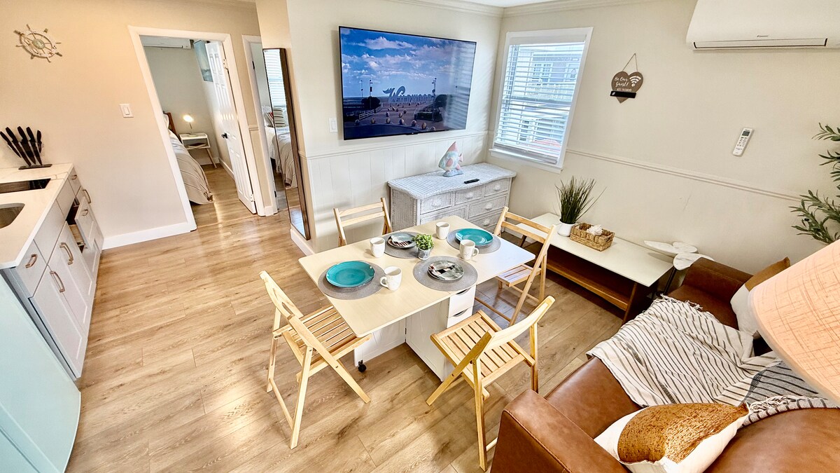 Bright and functional living area with a full kitchen, folding dining table, and a pull-out queen sofa. Every detail fol