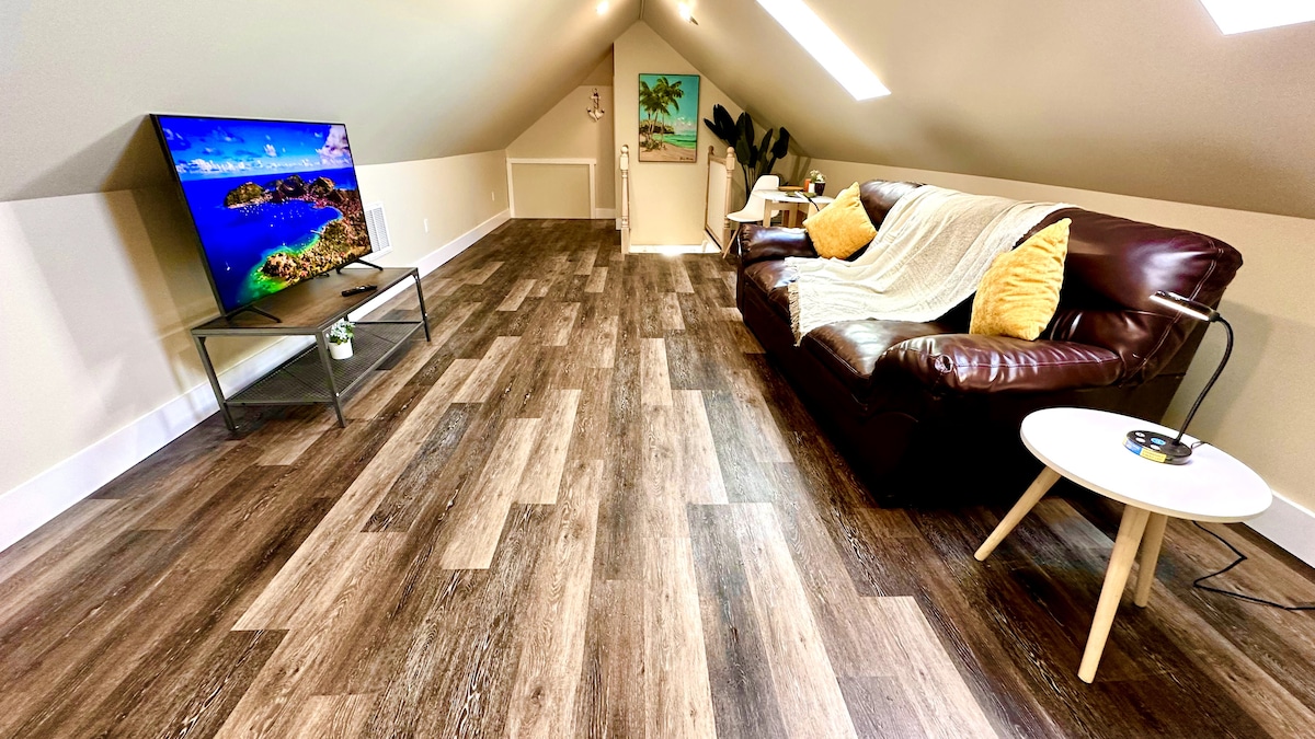 Enjoy luxury and comfort in our bright living room, boasting a cozy couch, 65-inch TV, and large sky windows that fill t