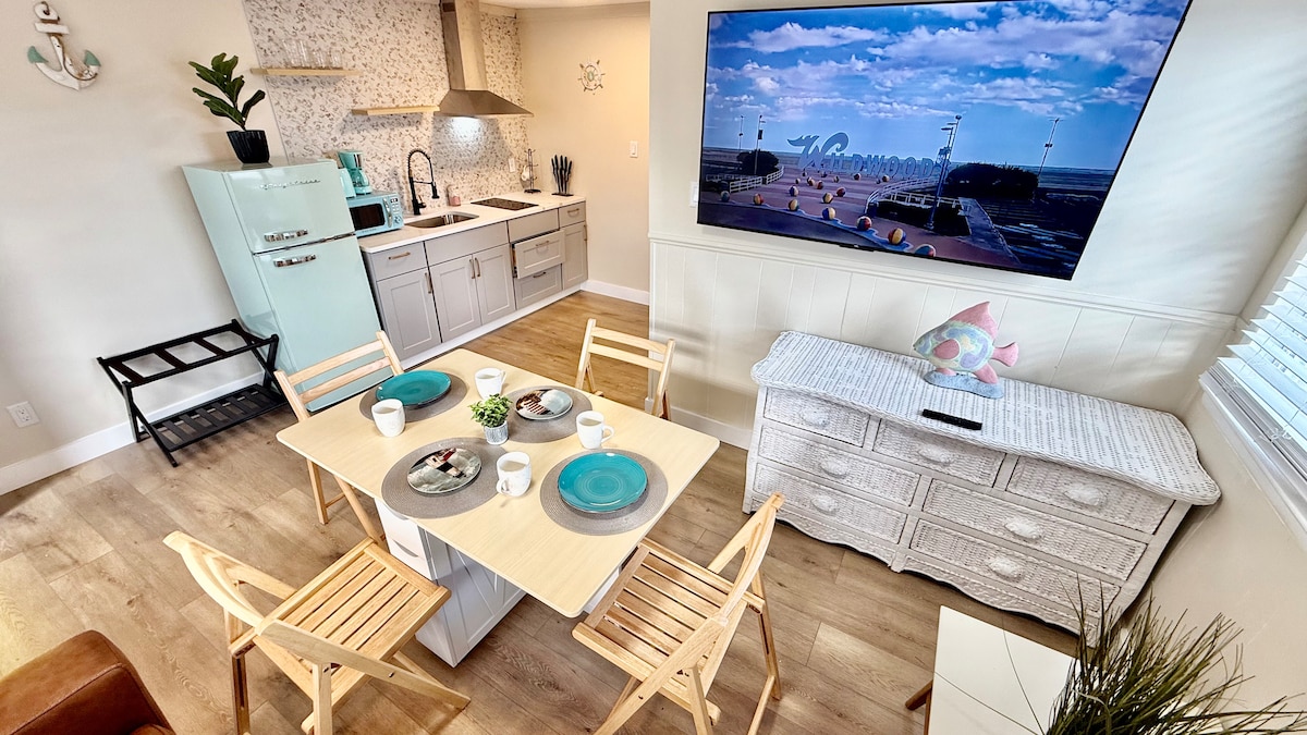 Bright and functional living area with a full kitchen, folding dining table, and a pull-out queen sofa. Every detail fol