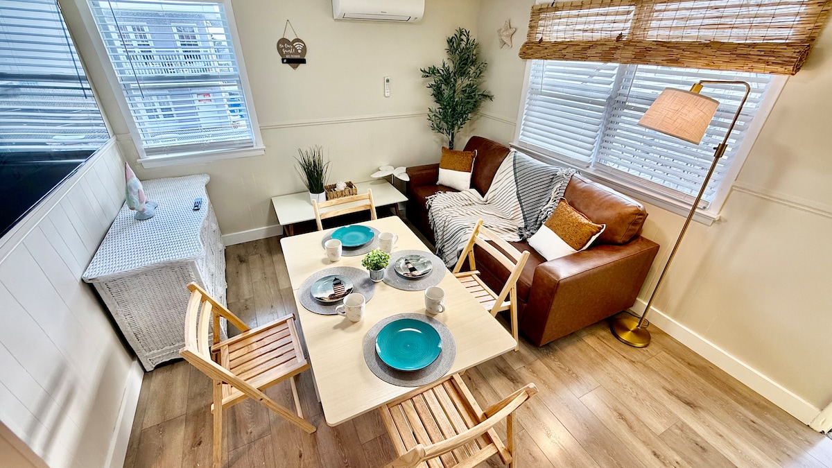 Bright and functional living area with a full kitchen, folding dining table, and a pull-out queen sofa. Every detail fol