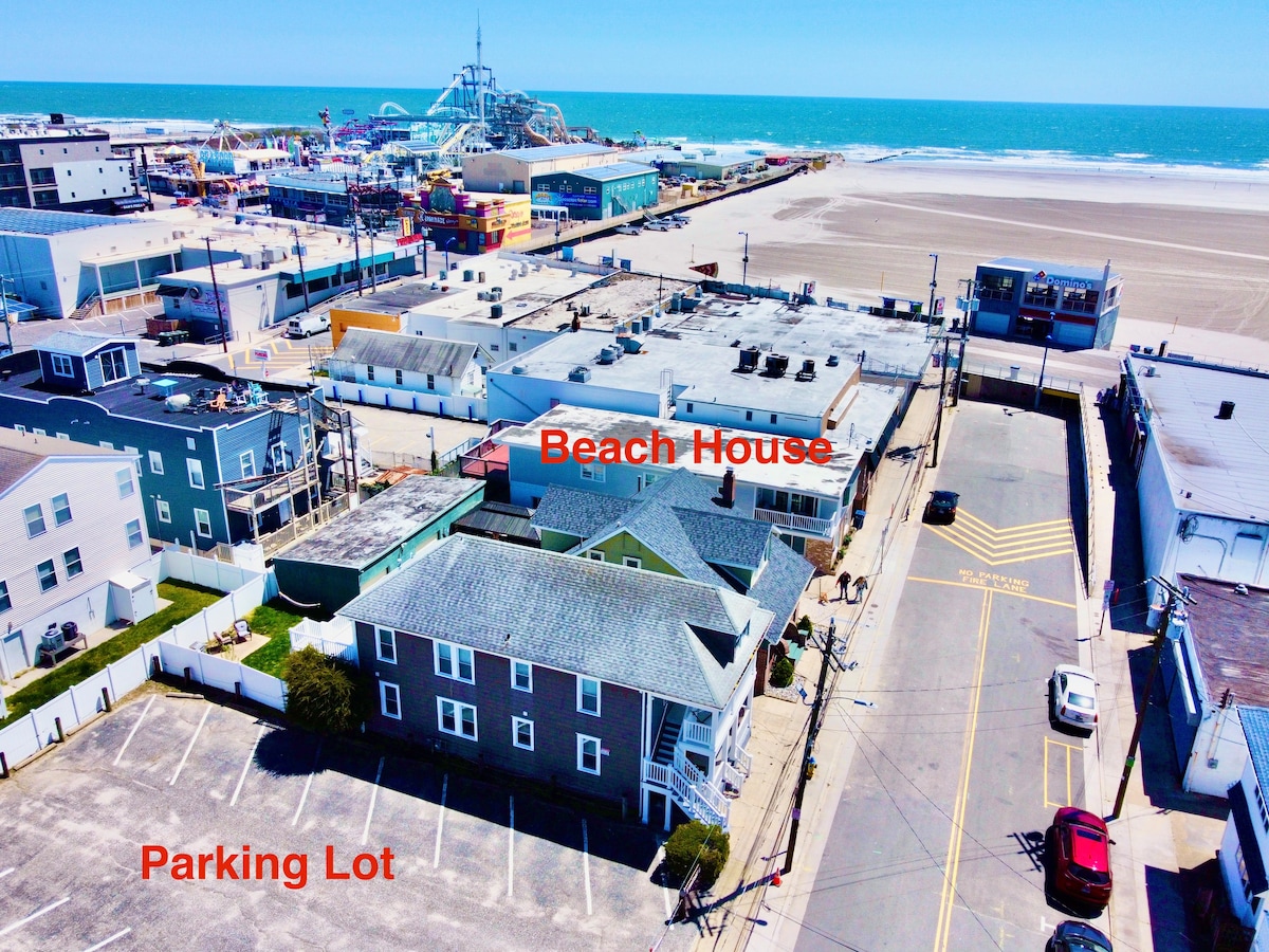 Aerial shot of the house near the beach with a parking lot close by