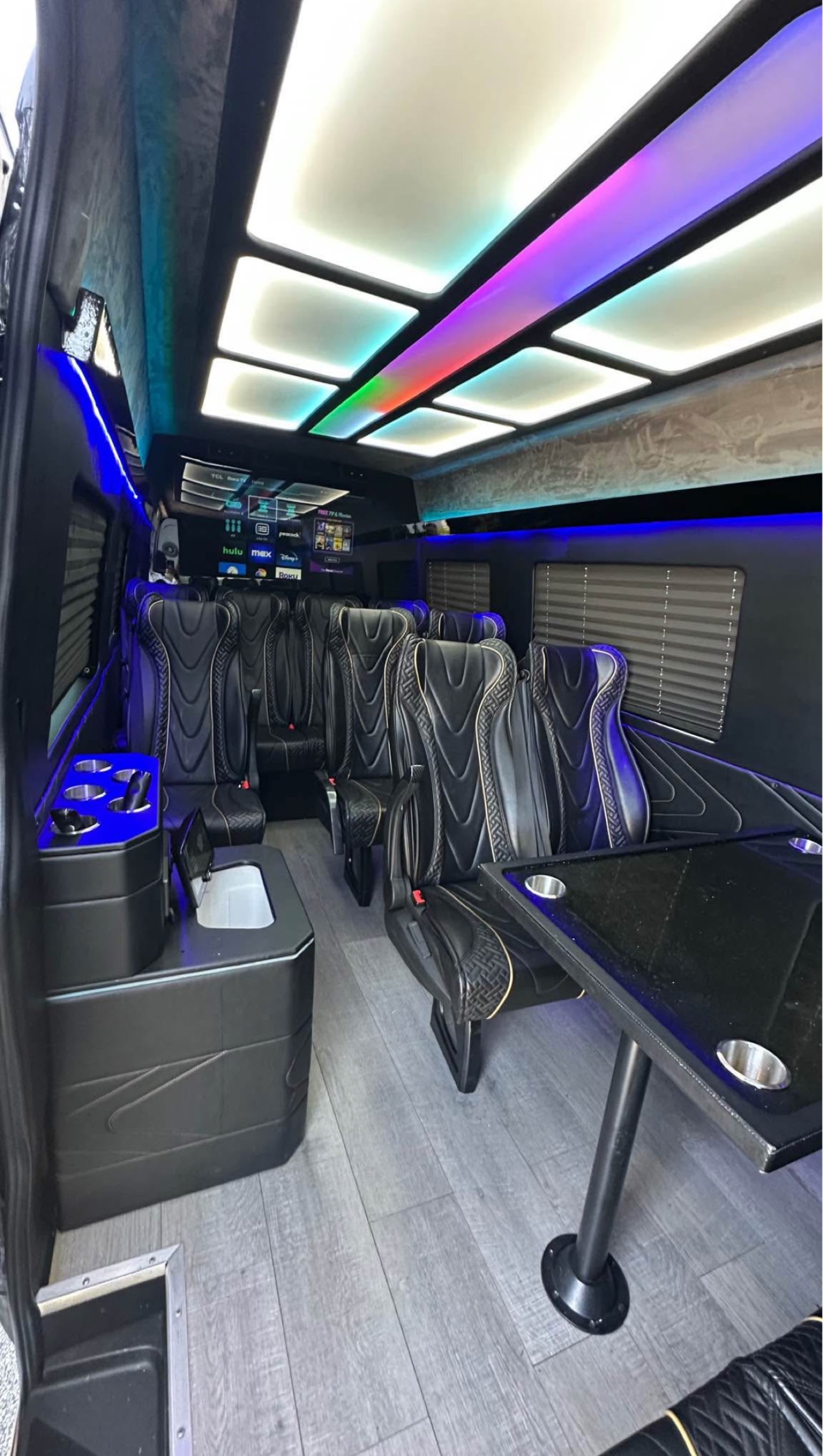 Executive party bus interior with colorful customizable ceiling lighting