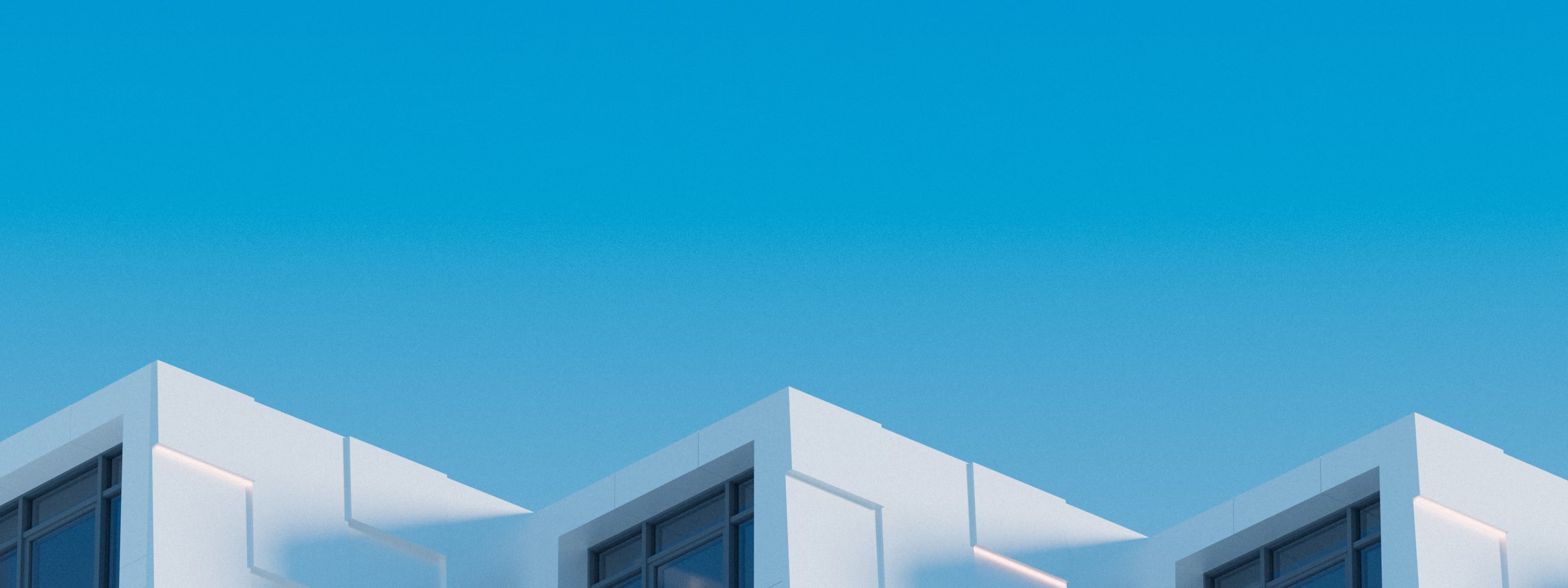 Modern white building with angular rooflines against a blue sky