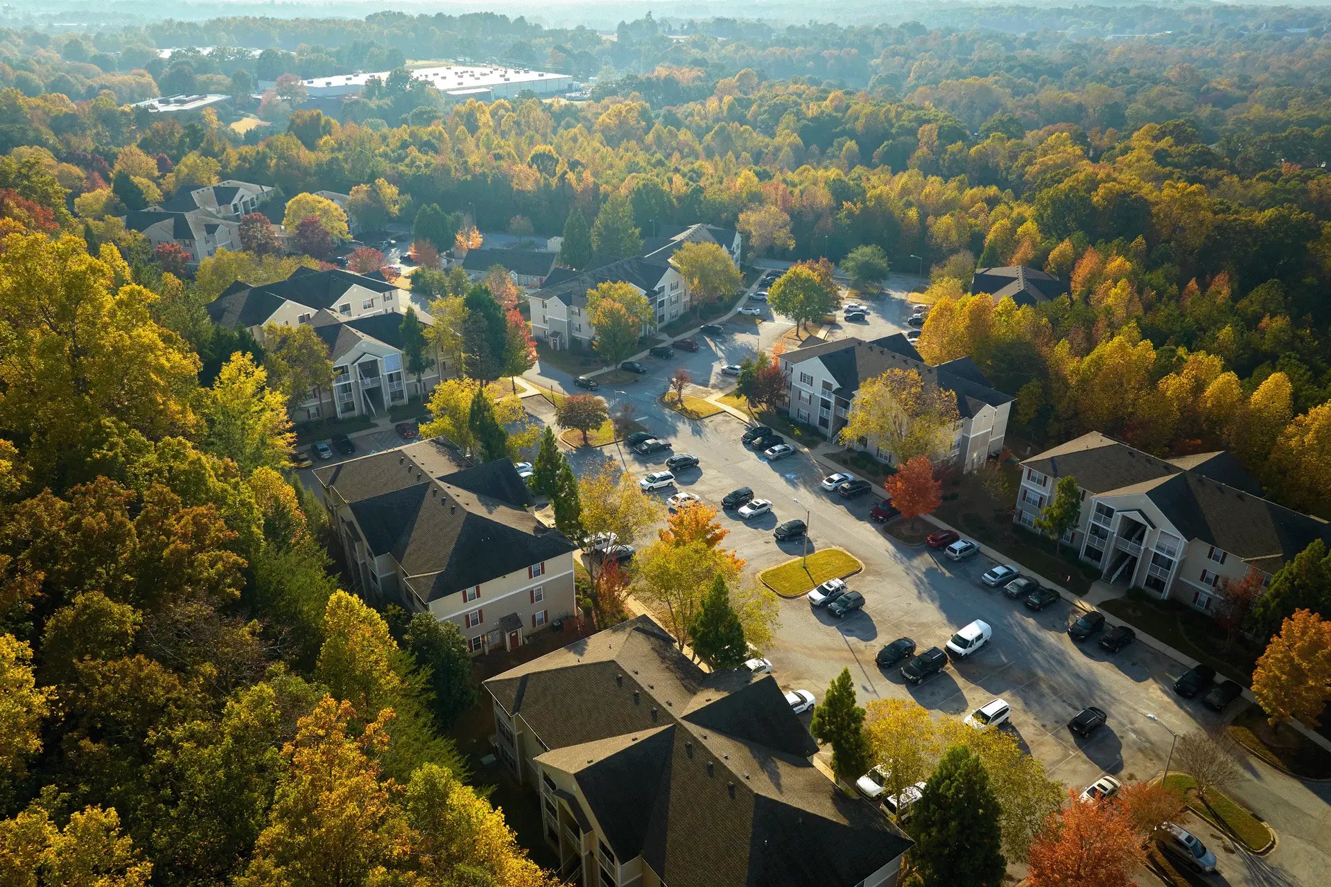 Aerial view of a suburban housing complex surrounded by trees in autumn