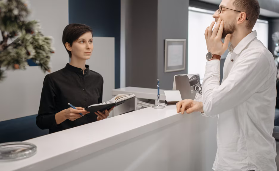 Receptionist tidying a bright office lobby desk
