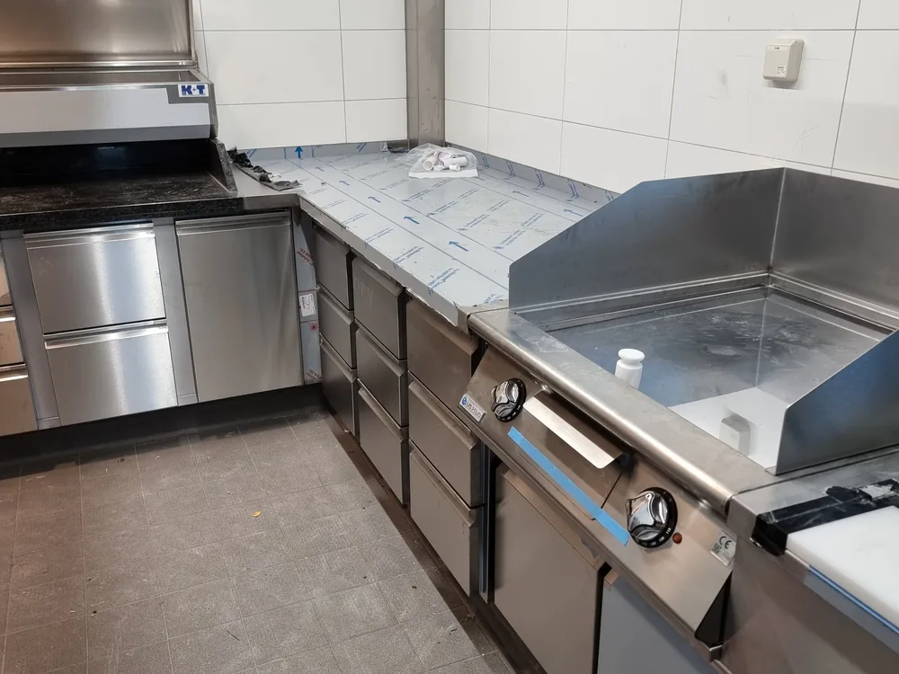 Eckzeile aus Edelstahl mit Grillplatte und Unterbaukühlung