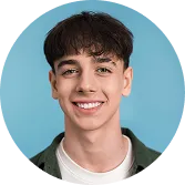 Portrait of a smiling young man with short dark hair against a blue background.