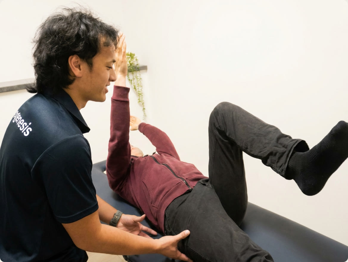 A Myogenesis practitioner guiding a client through a leg exercise on a treatment table