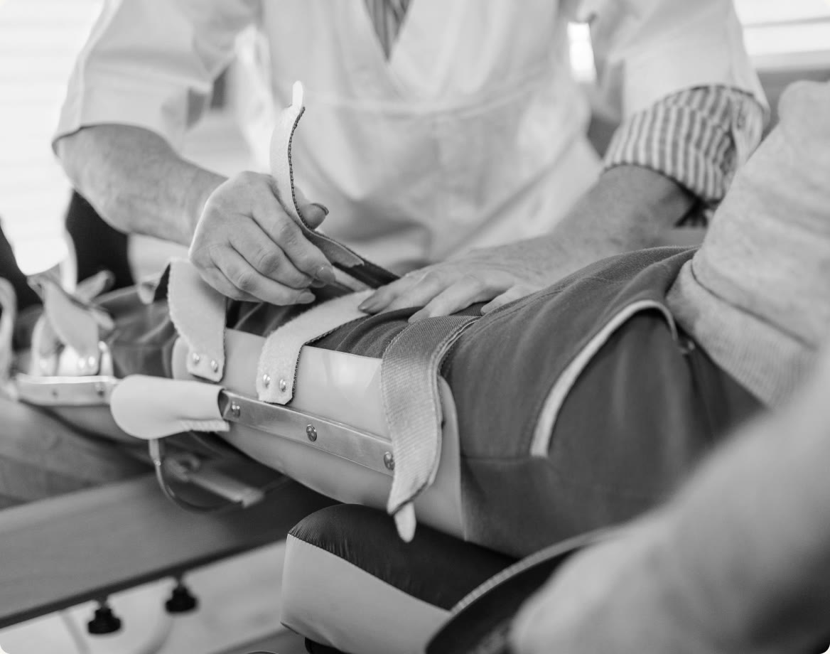 A person with their leg in a knee brace after surgery