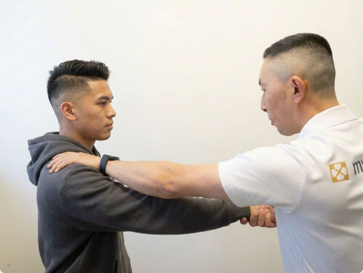 A Myogenesis practitioner assessing a client's shoulder and arm movement