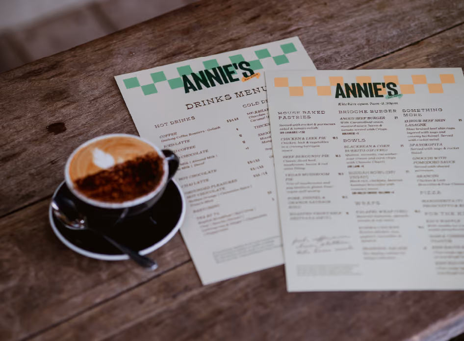 Annie's Provedore menus on table with coffee