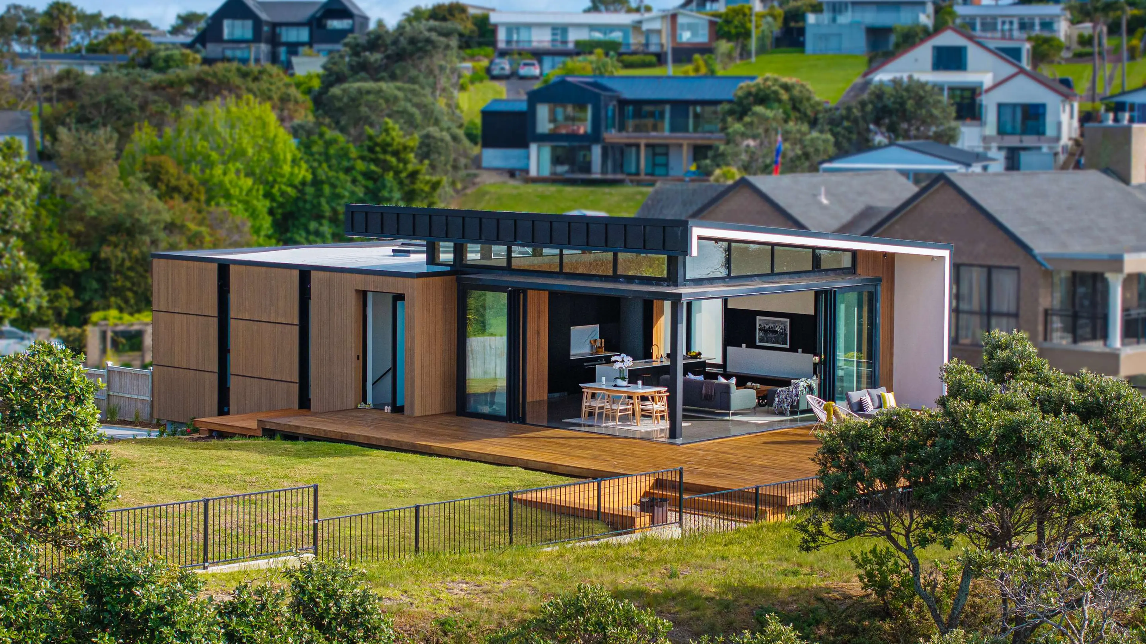 A modern cedar and glass home above the Mangere Bridge foreshore