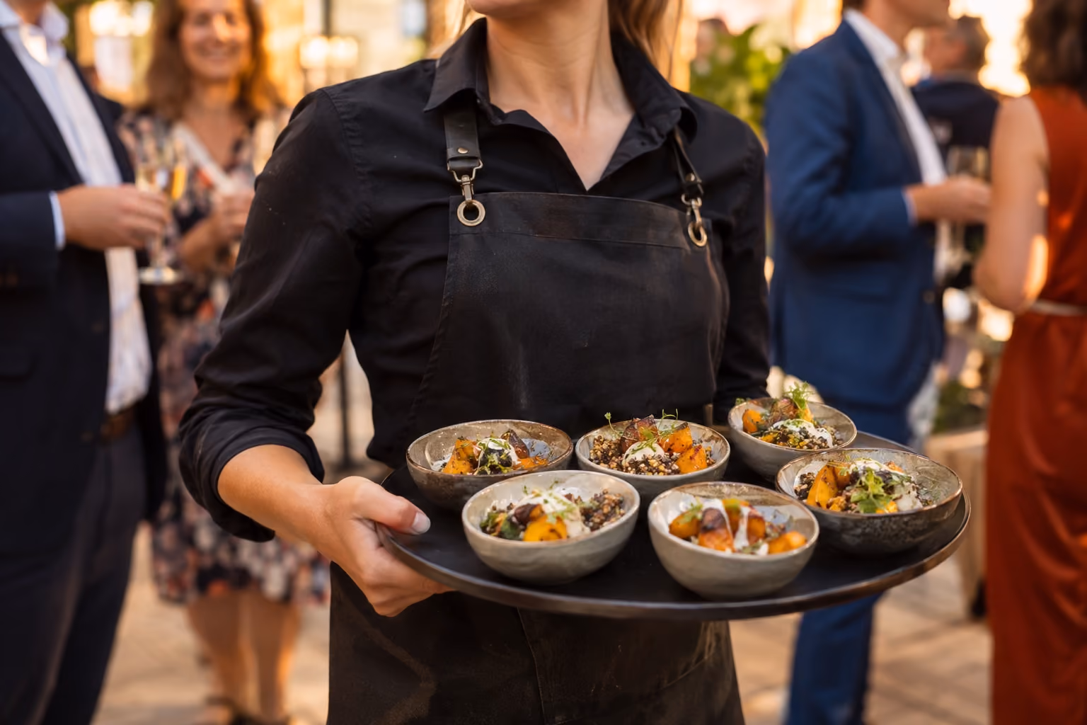 Een medewerker draagt kleine gerechten tijdens een walking dinner.