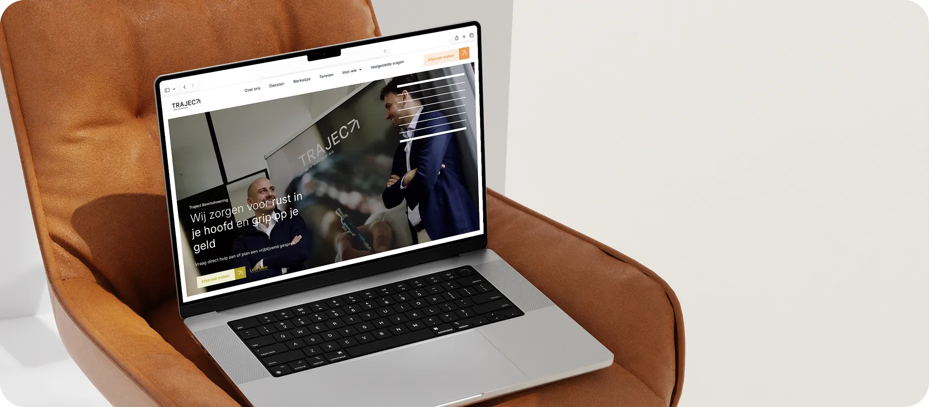 Afbeelding van een laptop op een oranje/bruine stoel en op de laptop is de website van Traject Bewindvoering te zien