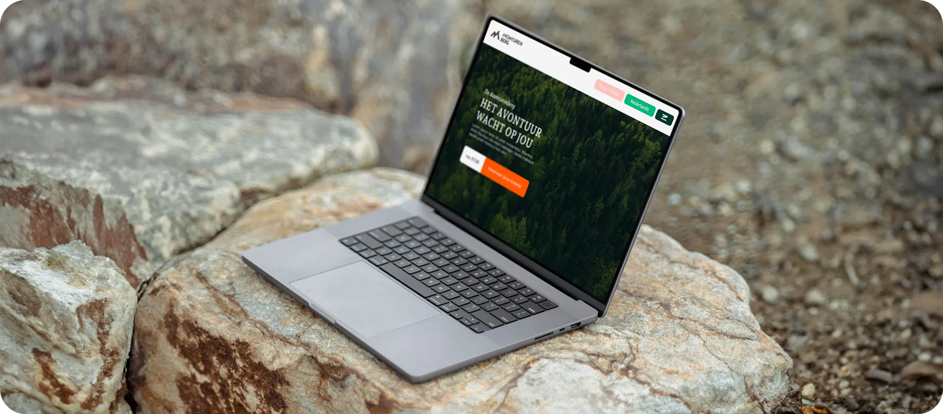 Afbeelding van de website van De Avonturenberg in een laptop op rotsen