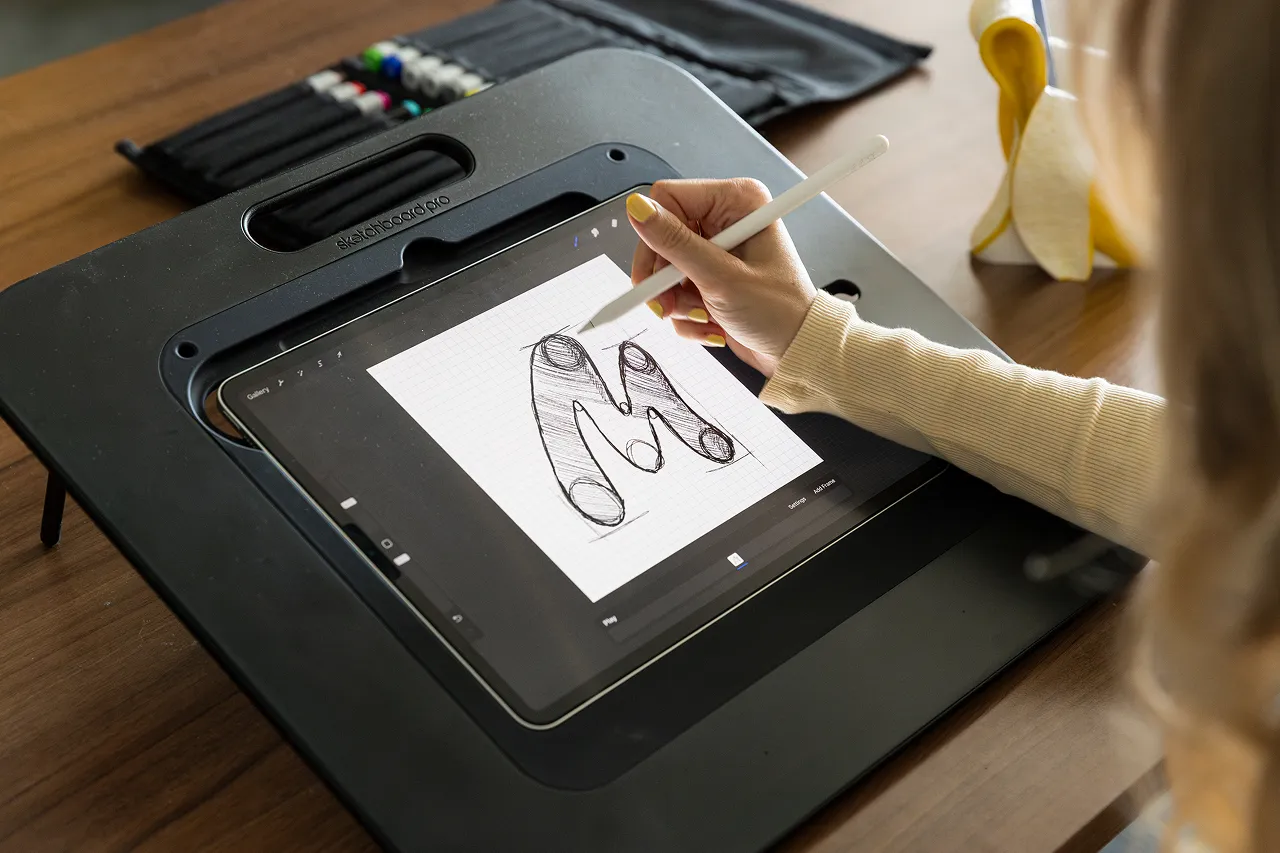 Een medewerker van Brandlos schetst een logo op de iPad met een apple pencil