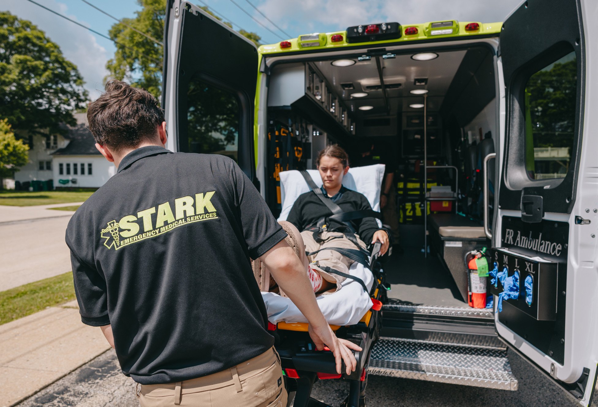 Stark County Ambulance crew transferring a patient on a stretcher at a hospital entrance