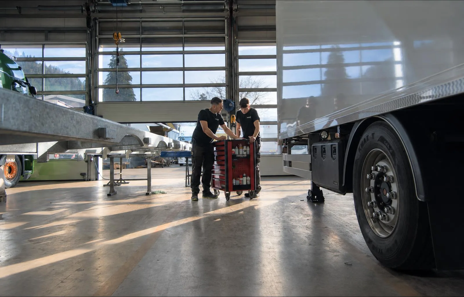 Zwei Mitarbeiter arbeiten am Sattelauflieger in der Werkshalle