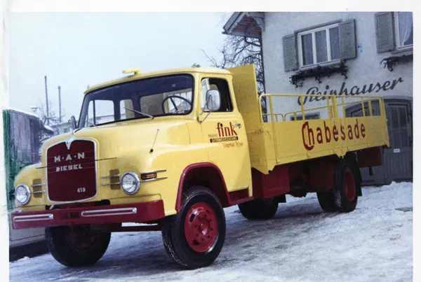 Gelber MAN-Pritschenwagen mit Beschriftung Chabesade im Schnee