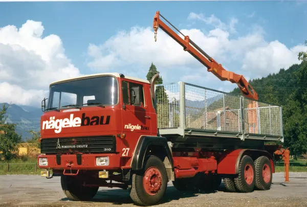 Roter Dreiachser von Nägele Bau mit Ladekran und Gitteraufbau