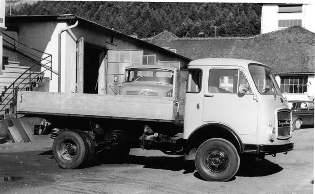Pritschen-Lkw vor einem Werkstattgebäude, Schwarzweiss