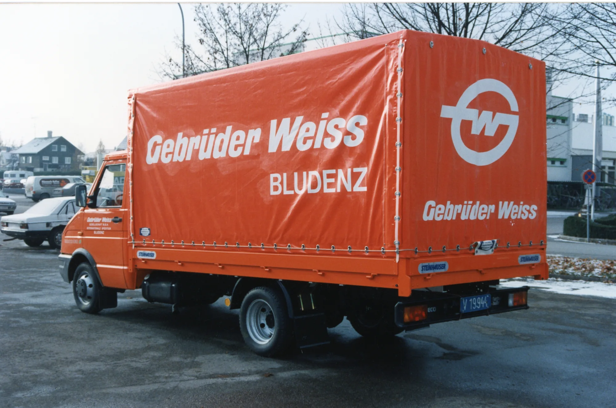 Orangefarbener Planen-Lkw von Gebrüder Weiss Bludenz