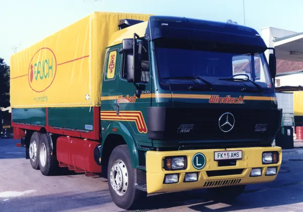 Mercedes-Dreiachser mit gelbem Planenaufbau