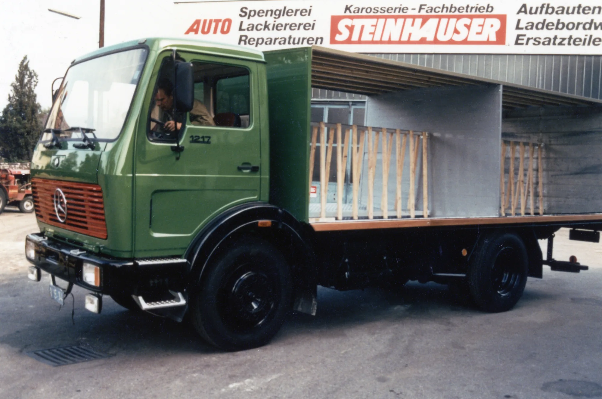 Grüner Mercedes mit offenem Pritschenaufbau vor der Steinhauser-Werkstatt