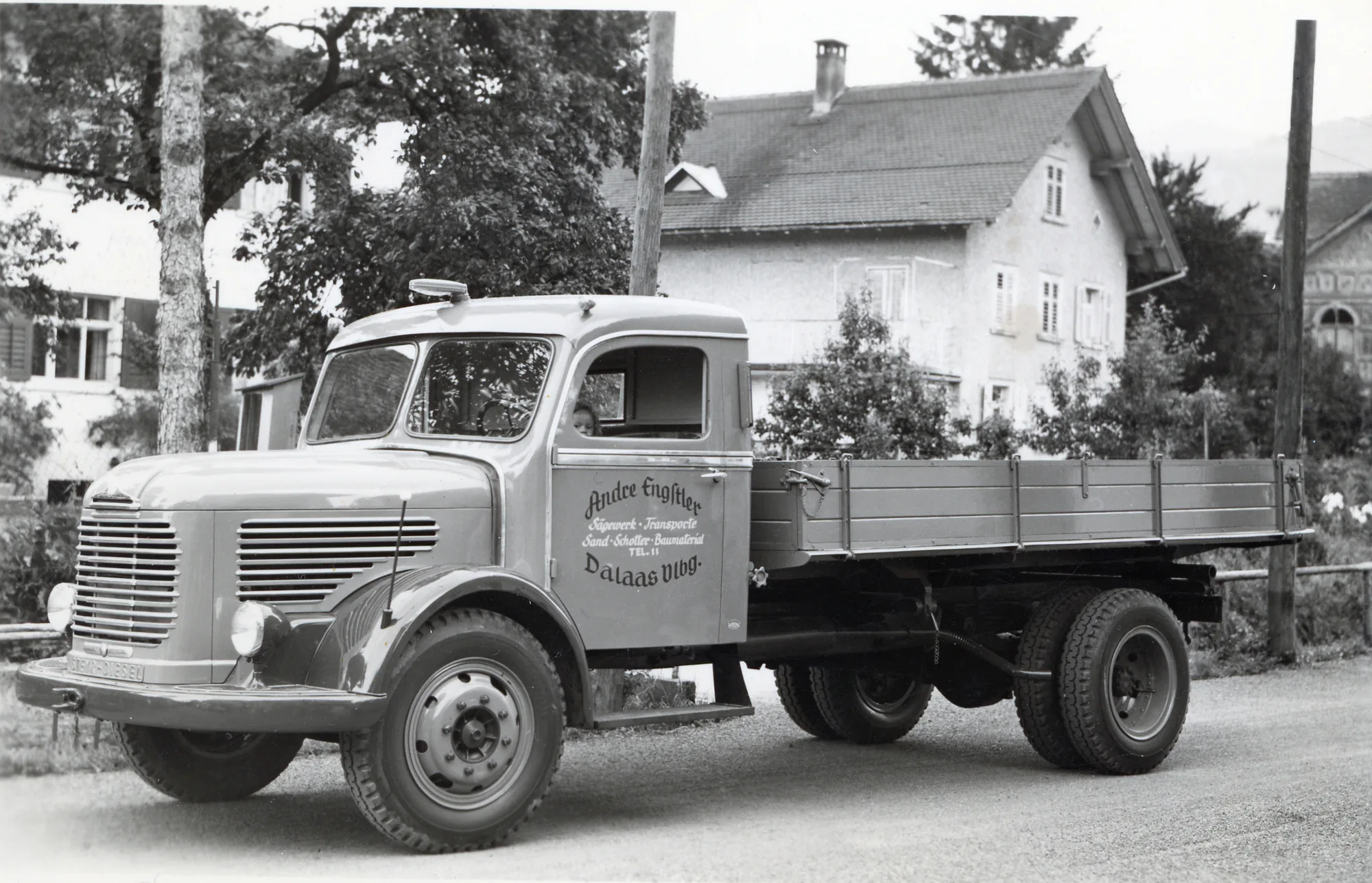 Pritschen-Lkw vor einem Wohnhaus, Schwarzweiss