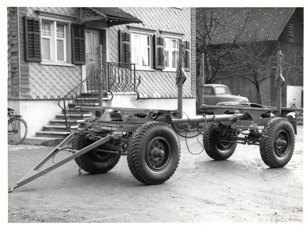 Anhänger-Fahrgestell vor einem Haus, Schwarzweiss